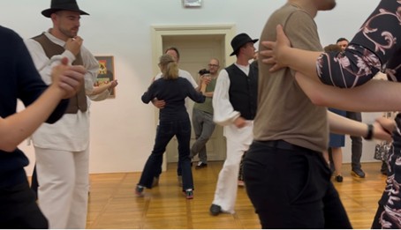 Flere par som danser slovensk folkedans